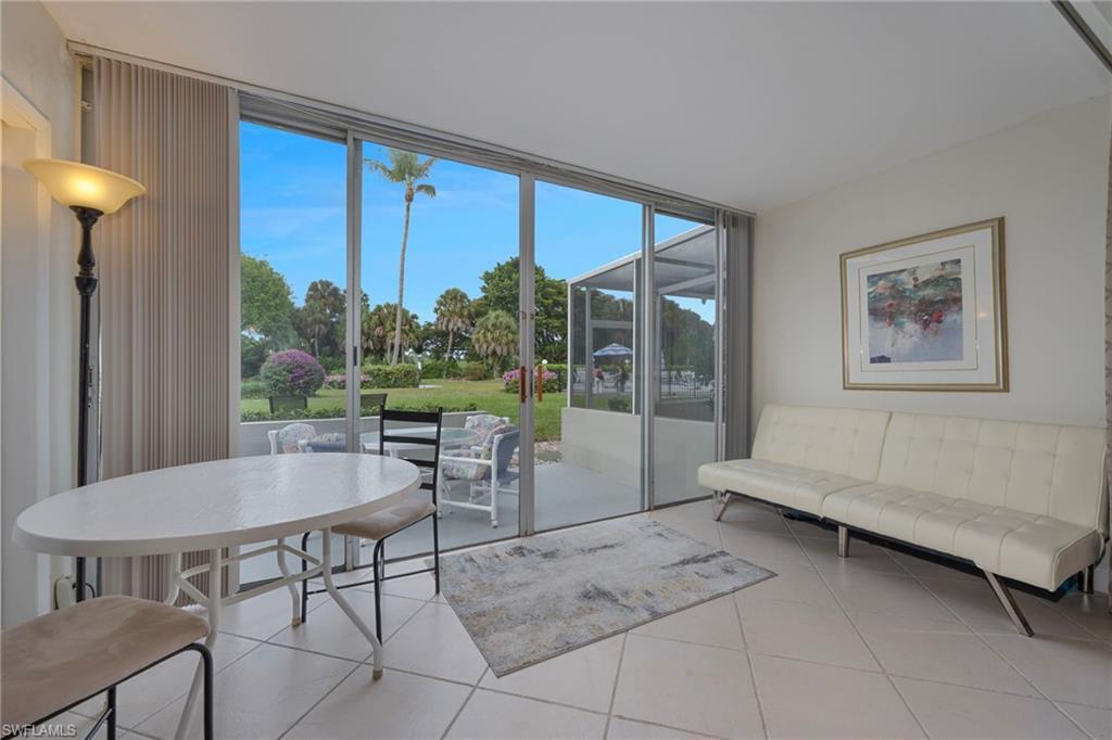 215 Cypress Way East, Unit C4 Naples, FL 34110 - Photo 12 of 15 a living room with furniture and a large window