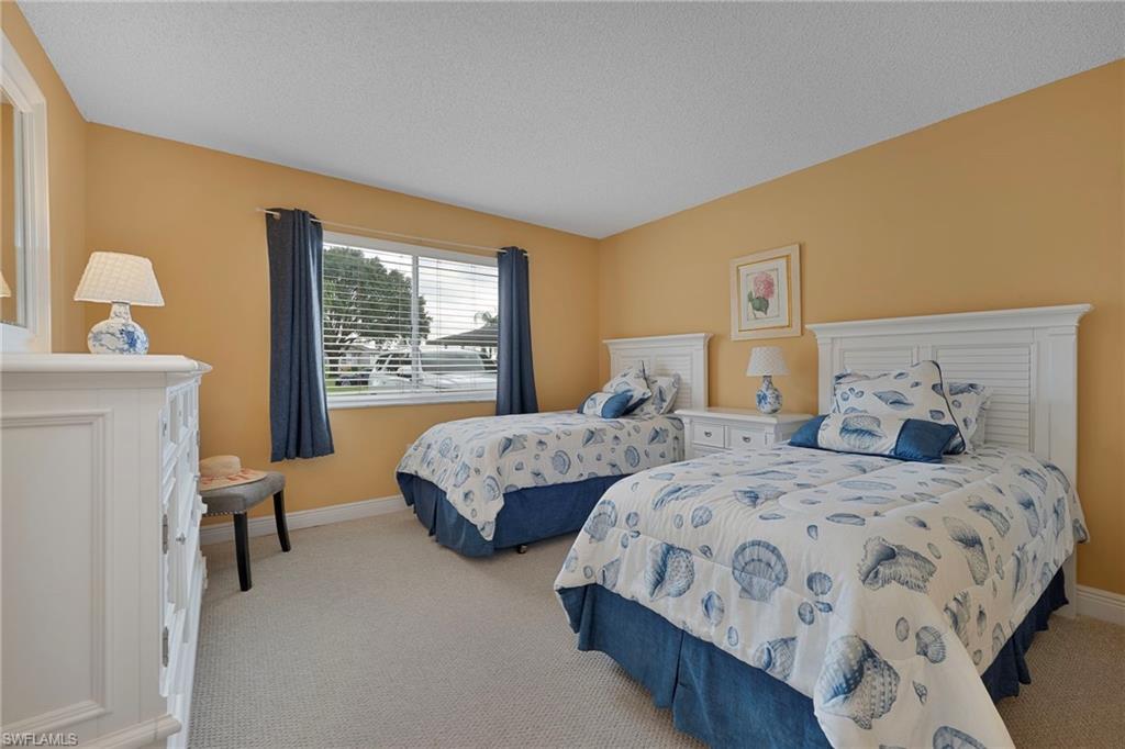 215 Cypress Way East, Unit C4 Naples, FL 34110 - Photo 9 of 15 a bedroom with two beds and a large window