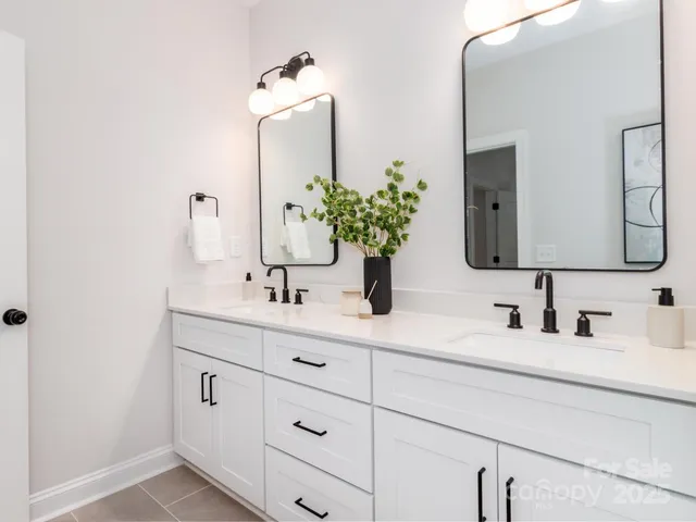 a bathroom with double vanity sinks and a mirror