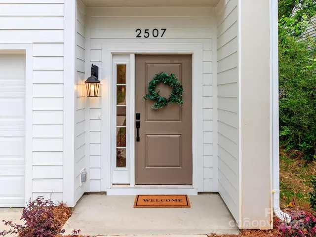 a front view of a house with a yard and trees