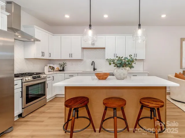 a kitchen with stainless steel appliances granite countertop a sink a stove and a refrigerator