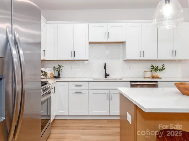a kitchen with a stove a sink and wooden floor