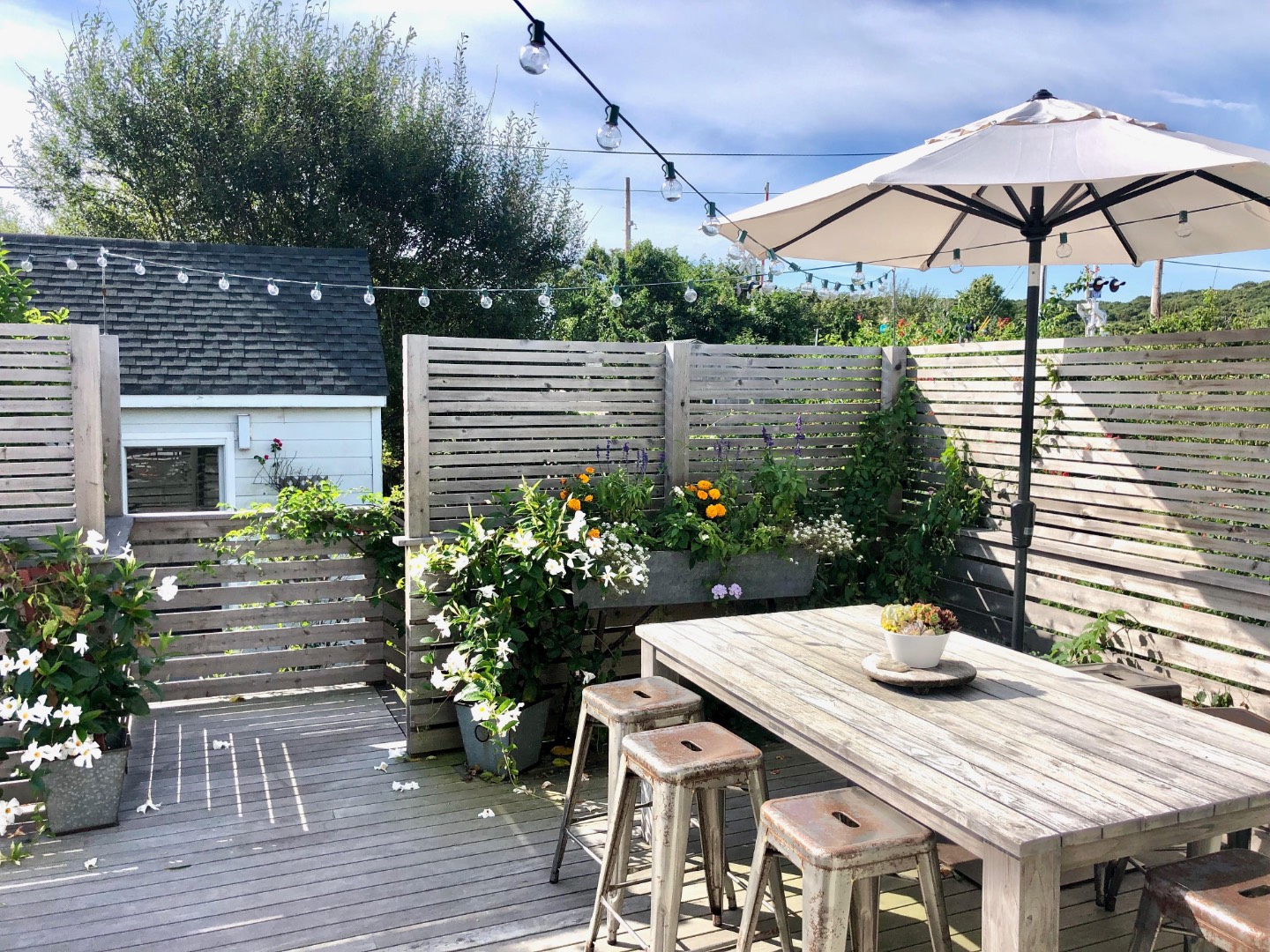 65 Navy Road Montauk, NY 11954 - Photo 13 of 20 a roof deck with table and chairs under an umbrella