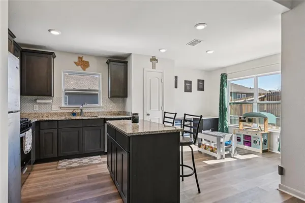 a kitchen with stainless steel appliances granite countertop a sink stove and cabinets