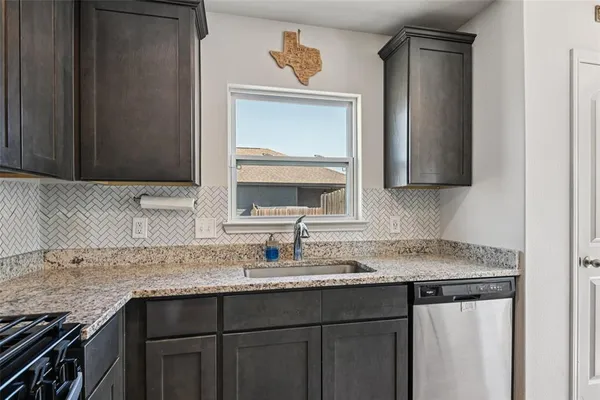 a kitchen with granite countertop a sink and cabinets