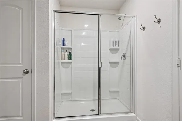a bathroom with a glass shower door