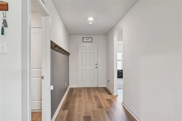 a view of a hallway with wooden floor and staircase