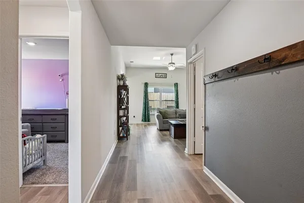 a view of a hallway with a livingroom and a bathroom