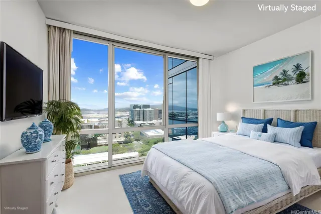 a bedroom with a large bed and a flat tv screen next to a window