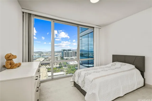 a bedroom with a bed and large windows