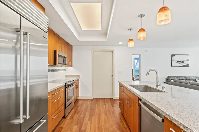 a kitchen with stainless steel appliances granite countertop a sink a stove and refrigerator
