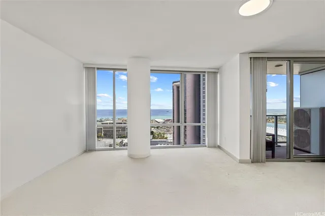 a view of an empty room with glass door and a window