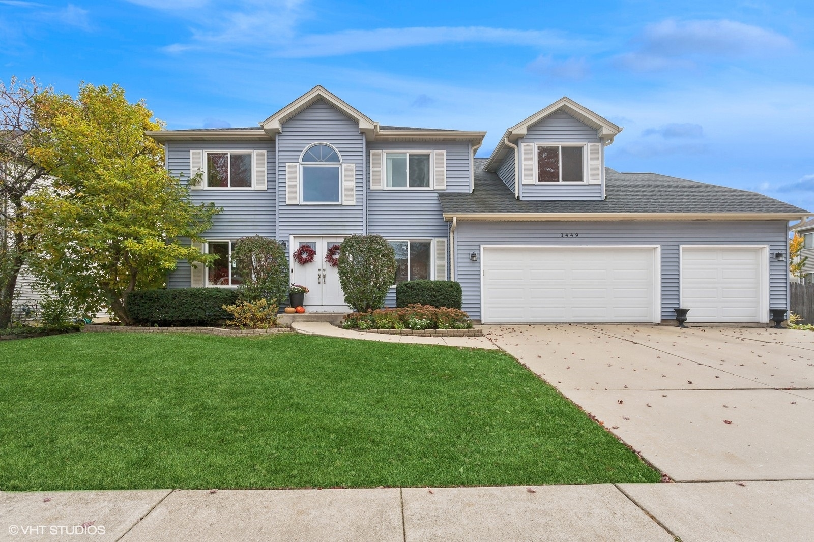 a front view of a house with a garden and yard