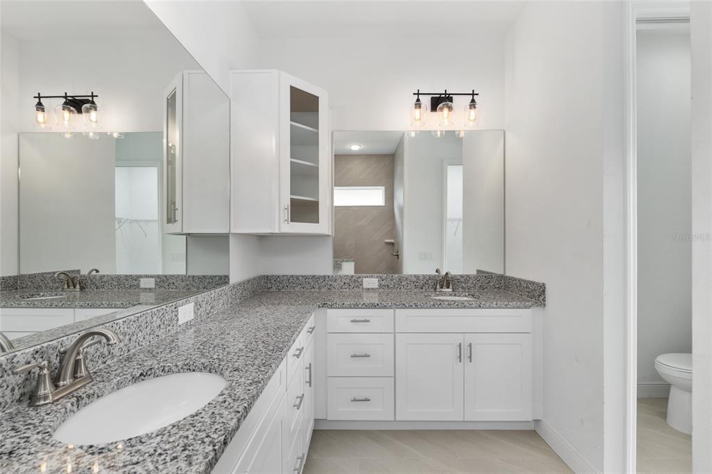 4722 Southeast 25th Loop Ocala, FL 34480 - Photo 24 of 38 a bathroom with a granite countertop sink double vanity and a mirror