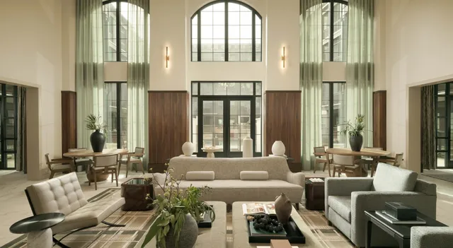 a living room with furniture fireplace and large windows