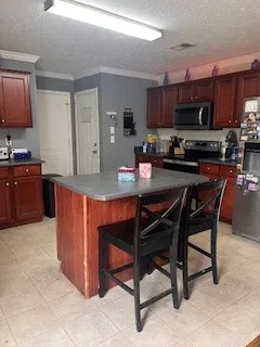 a kitchen with granite countertop a table chairs microwave and cabinets