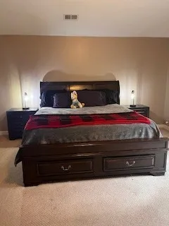 a bed sitting in a bedroom next to a lamp
