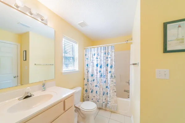 a bathroom with a sink a toilet and shower curtain