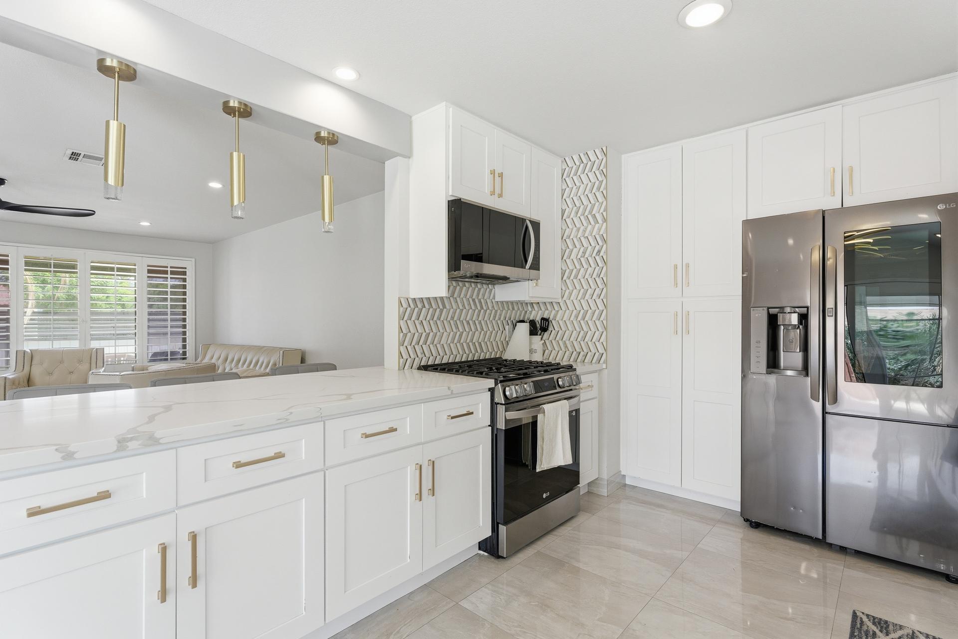 40961 Cecina Way Bermuda Dunes, CA 92203 - Photo 11 of 27 a kitchen with granite countertop white cabinets and stainless steel appliances
