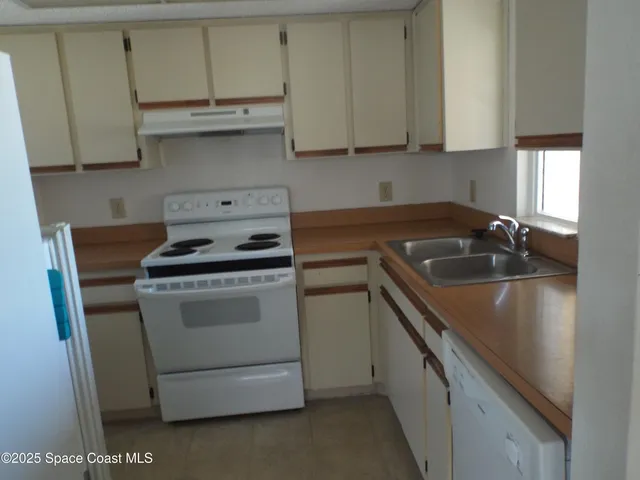 a kitchen with cabinets appliances a sink and a counter top