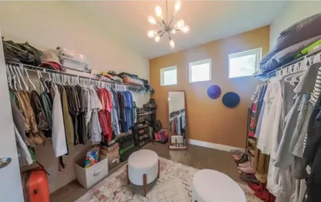a view of walk in closet with clothes and shoes