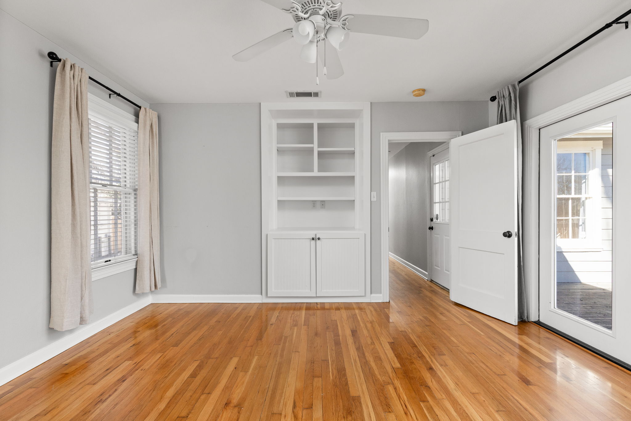 4517 Bull Creek Road Austin, TX 78731 - Photo 17 of 35 an empty room with wooden floor cabinet and windows