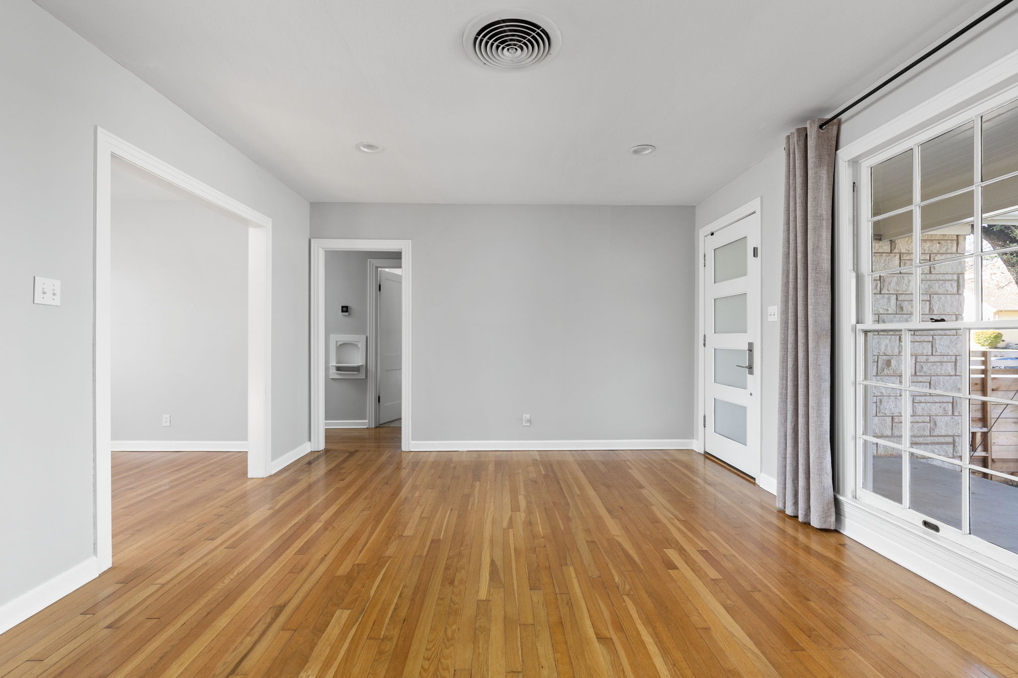 4517 Bull Creek Road Austin, TX 78731 - Photo 6 of 35 a view of an empty room with wooden floor and a window