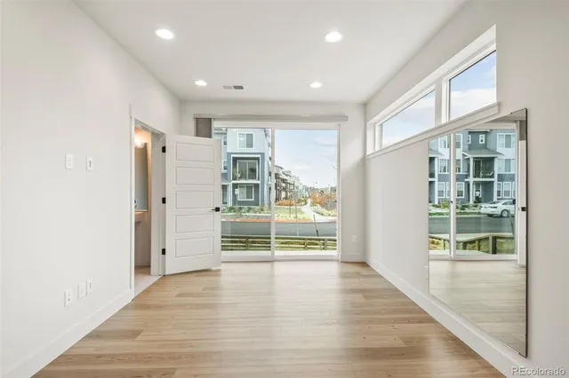 a view of empty room with wooden floor and windows