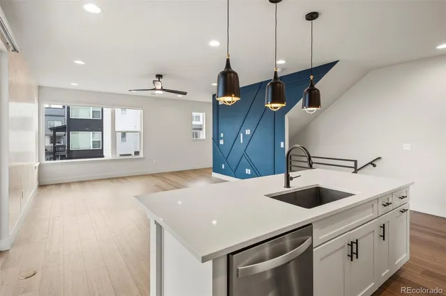 a kitchen with a sink a island and stainless steel appliances