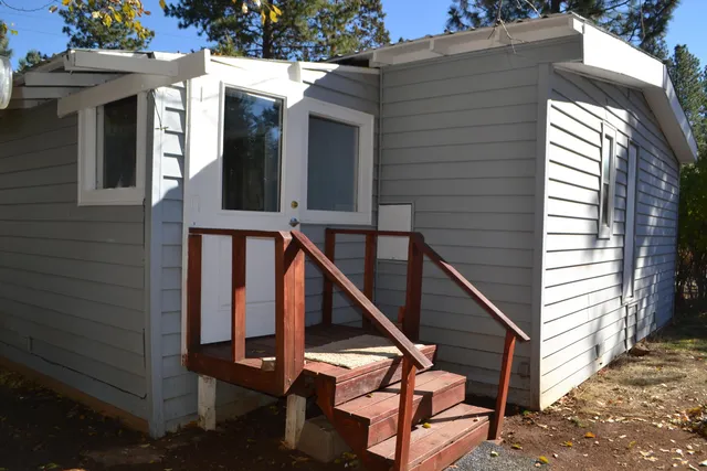 a view of backyard of house with green space