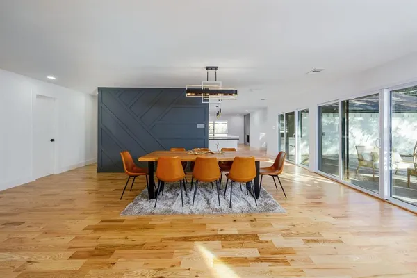 a dining room with furniture a chandelier and wooden floor