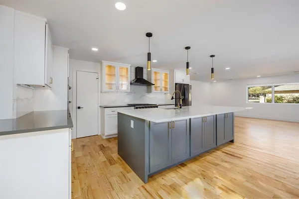 a kitchen with stainless steel appliances granite countertop a sink and a refrigerator