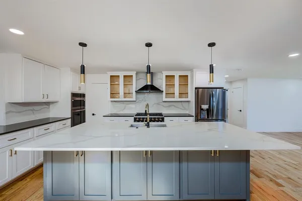 a kitchen with kitchen island a counter top space appliances and cabinets