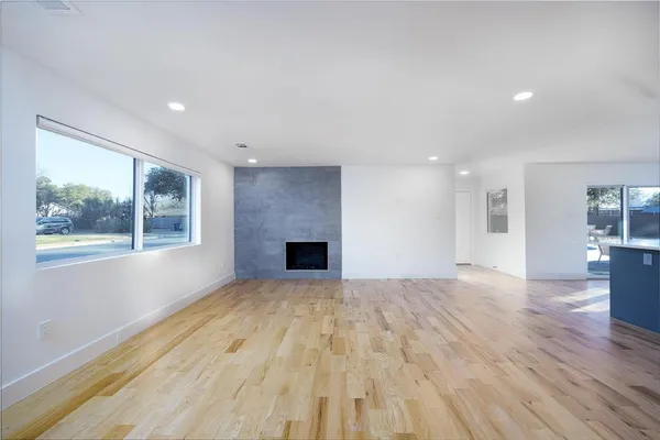 a view of empty room with wooden floor and fireplace