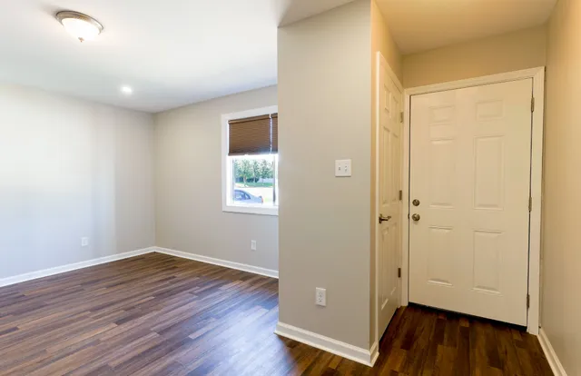 an empty room with wooden floor and a window