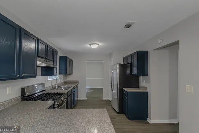 a kitchen with stainless steel appliances a refrigerator and a stove top oven