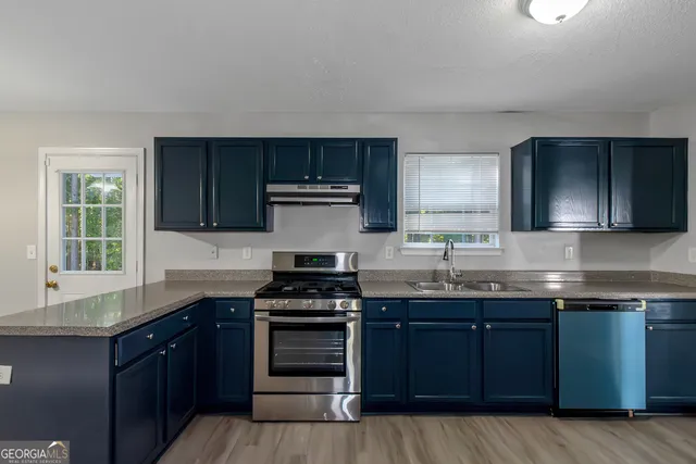 a kitchen with granite countertop wooden cabinets and stainless steel appliances