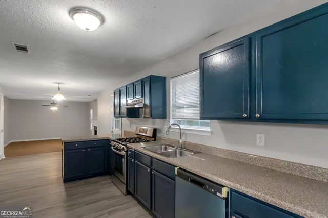 a kitchen with a sink and a stove top oven