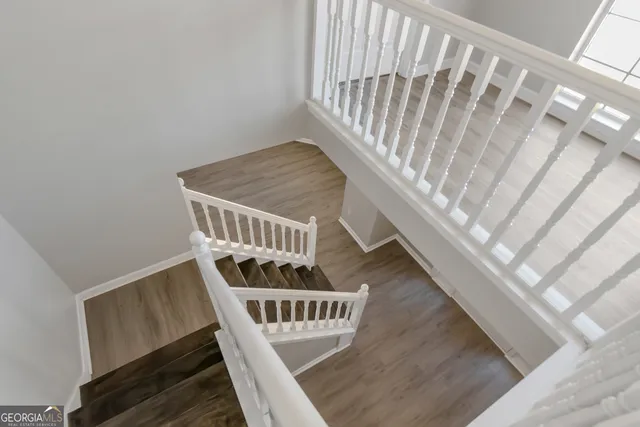 a view of staircase with railing and white walls