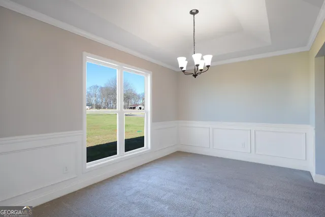 a view of a livingroom with a chandelier fan and windows