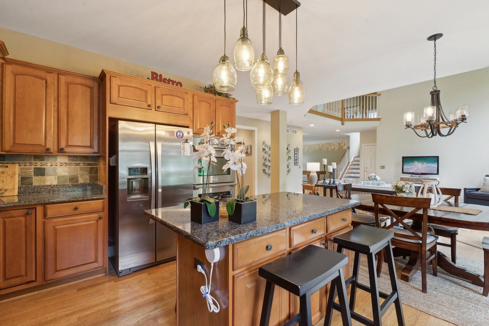 2156 Red Maple Lane Aurora, IL 60502 - Photo 25 of 57 a kitchen with stainless steel appliances granite countertop a table chairs stove and refrigerator