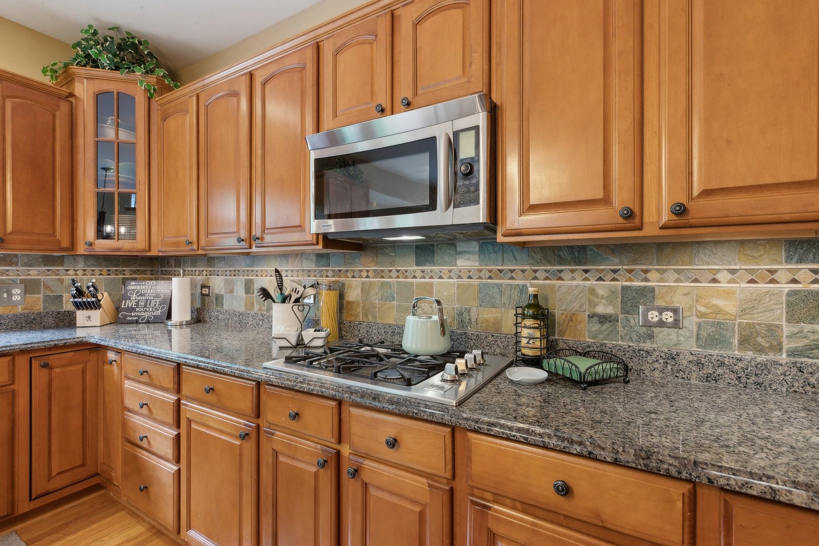 2156 Red Maple Lane Aurora, IL 60502 - Photo 26 of 57 a kitchen with stainless steel appliances granite countertop a sink a stove and a microwave