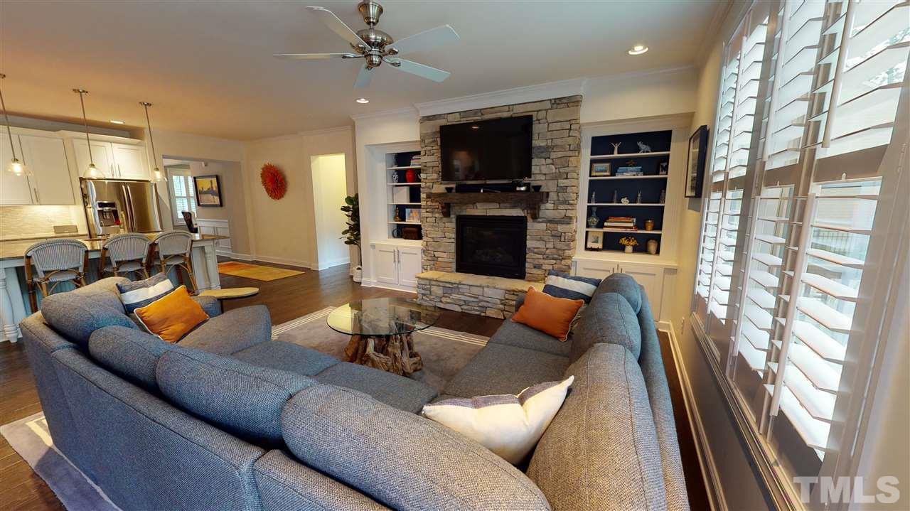 3116 Umstead View Drive Raleigh, NC 27607 - Photo 9 of 30 Cozy living room features access to the kitchen, outdoors, a stone fireplace, shutters, cabinets and built in shelving!