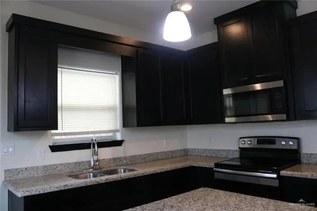 an empty room with wooden floor closet and windows