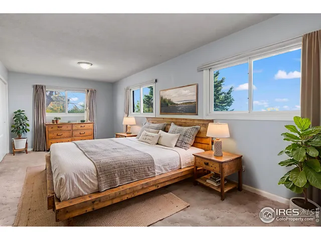 a bedroom with a bed table chair and window