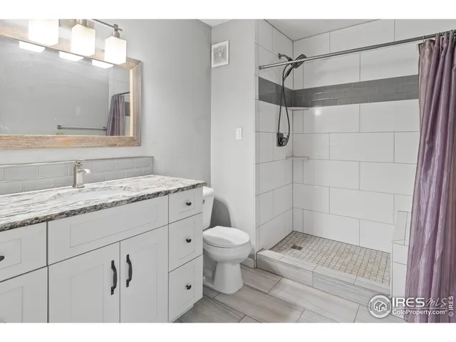 a bathroom with a sink toilet vanity and shower