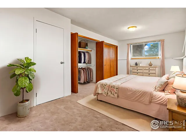 a bedroom with a large bed and a potted plant