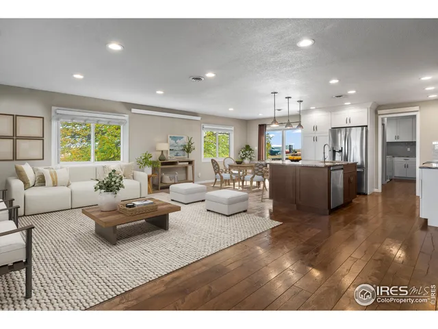 a living room with furniture kitchen and a wooden floor