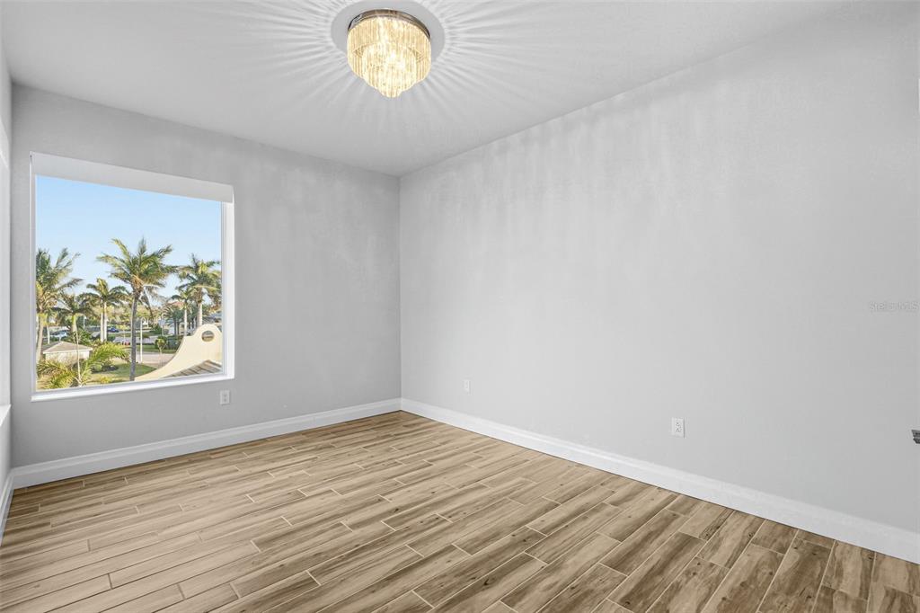 800 Collany Road, Unit 302 St. Petersburg, FL 33715 - Photo 32 of 66 an empty room with wooden floor and windows