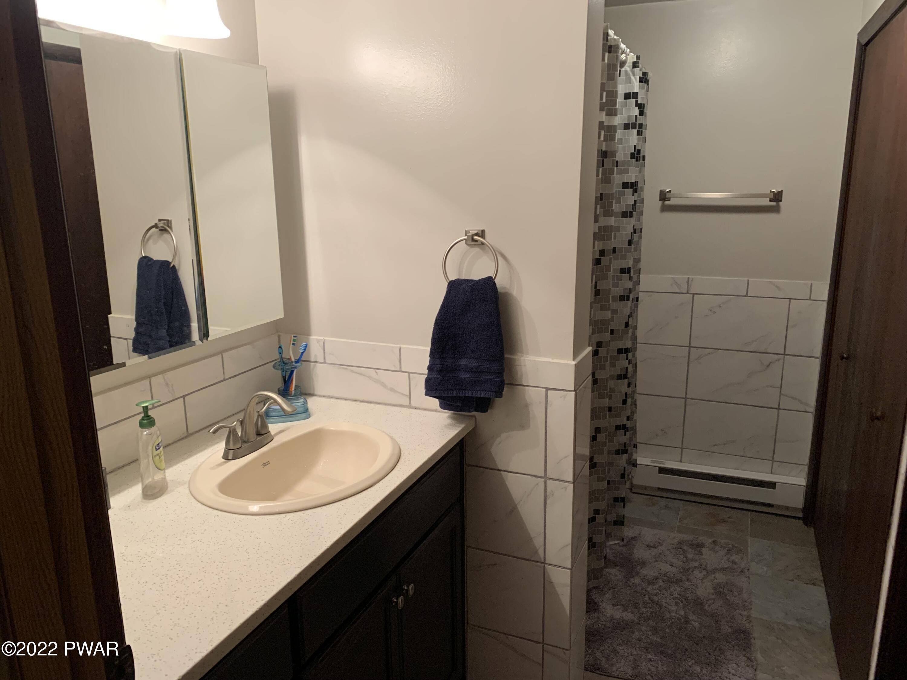 111 Rodeo Lane Hawley, PA 18428 - Photo 13 of 23 a bathroom with a sink and a mirror